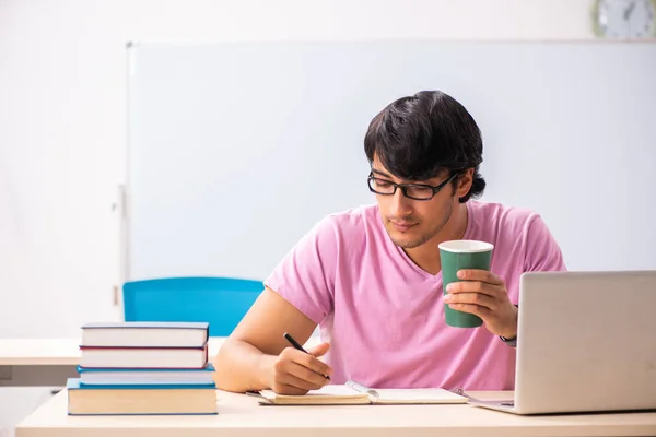 Mladý muž student sedí ve třídě — Stock fotografie