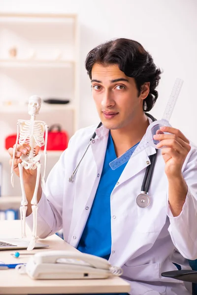 Jovem médico masculino com esqueleto — Fotografia de Stock