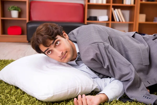 Jeune employé dormant par terre au bureau — Photo