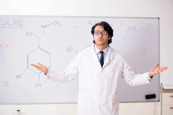 Jeune chimiste drôle devant le tableau blanc — Photo