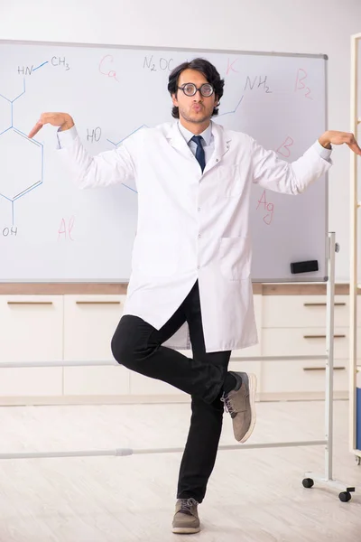 Joven químico divertido delante de la pizarra blanca —  Fotos de Stock