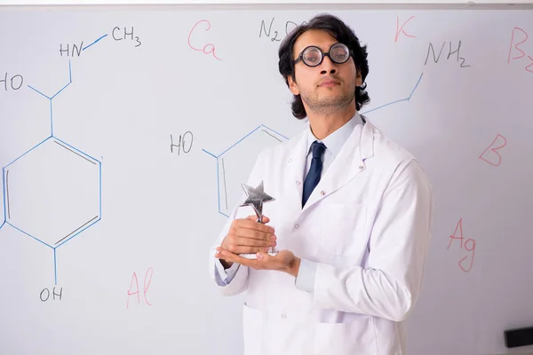 Joven químico divertido delante de la pizarra blanca —  Fotos de Stock