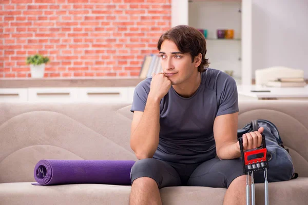 Joven hombre guapo haciendo ejercicios deportivos en casa — Foto de Stock