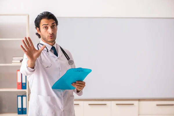 Ung läkare framför whiteboard — Stockfoto