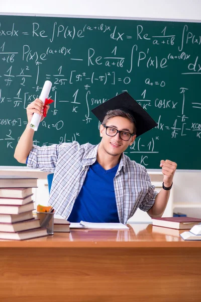 Jonge mannelijke student studeert wiskunde op school — Stockfoto