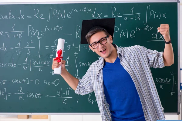 Ung manlig student som studerar matematik i skolan — Stockfoto