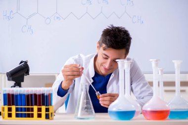 Laboratuarda oturan genç kimyager 