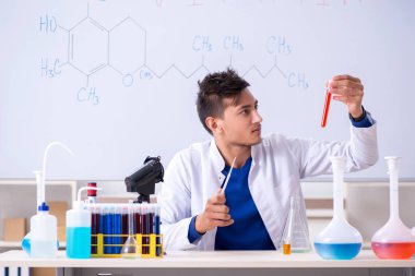 Laboratuarda oturan genç kimyager 