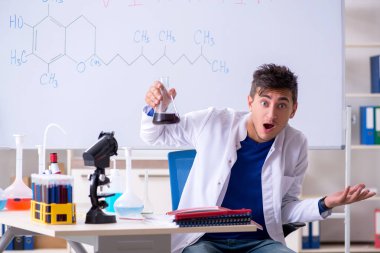 Laboratuarda oturan genç kimyager 