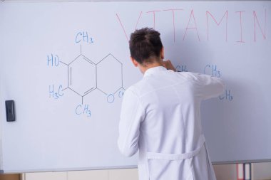 Beyaz tahta önünde duran genç kimyager 