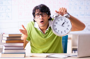 Genç erkek öğrenci kimyager önünde periyodik tablo 