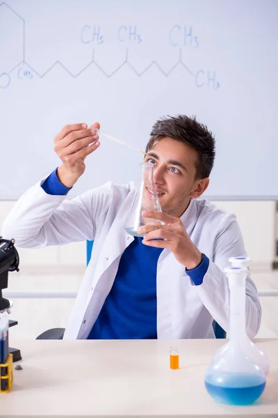 Joven químico sentado en el laboratorio — Foto de Stock