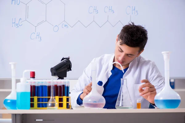 Молодий хімік сидить у лабораторії — стокове фото
