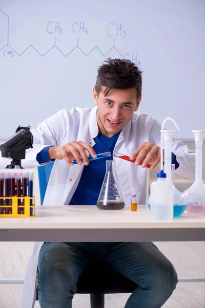 Jovem químico sentado no laboratório — Fotografia de Stock