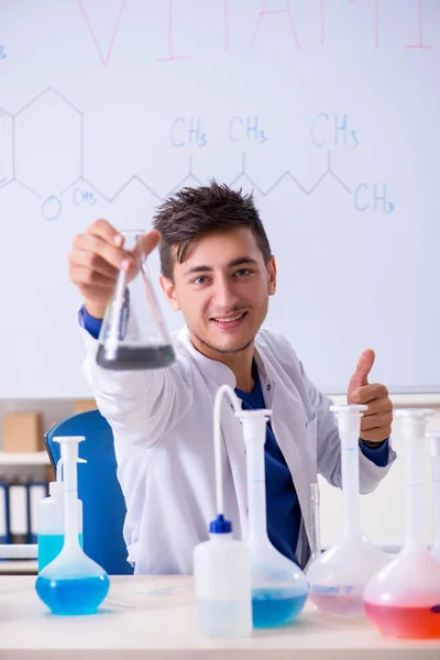 Młody chemik siedzi w laboratorium — Zdjęcie stockowe