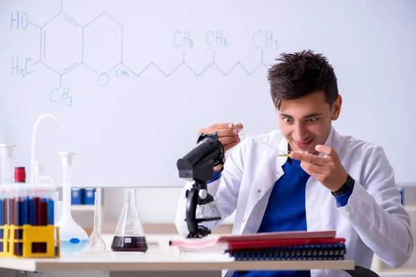 研究室で座っている若い化学者 — ストック写真