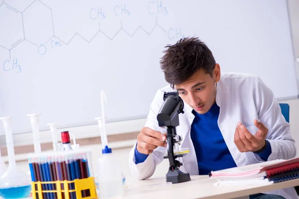 Joven químico sentado en el laboratorio — Foto de Stock