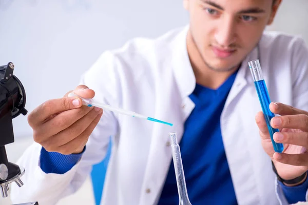 Joven químico sentado en el laboratorio —  Fotos de Stock