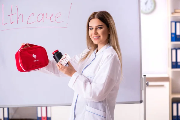 Doctora joven de pie frente a la pizarra blanca —  Fotos de Stock