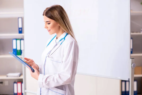 흰 칠판 앞에서 있는 젊은 여자 의사 — 스톡 사진