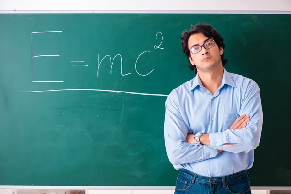 ฟิสิกส์ชายหนุ่มยืนอยู่หน้ากระดานสีเขียว — ภาพถ่ายสต็อก