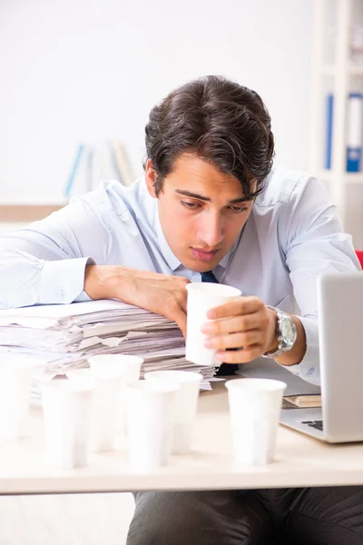 Jovem funcionário viciado em café — Fotografia de Stock