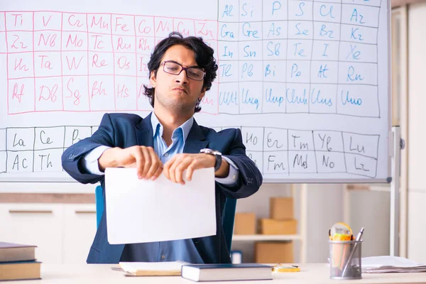 Молодой учитель химии перед таблицей Менделеева — стоковое фото