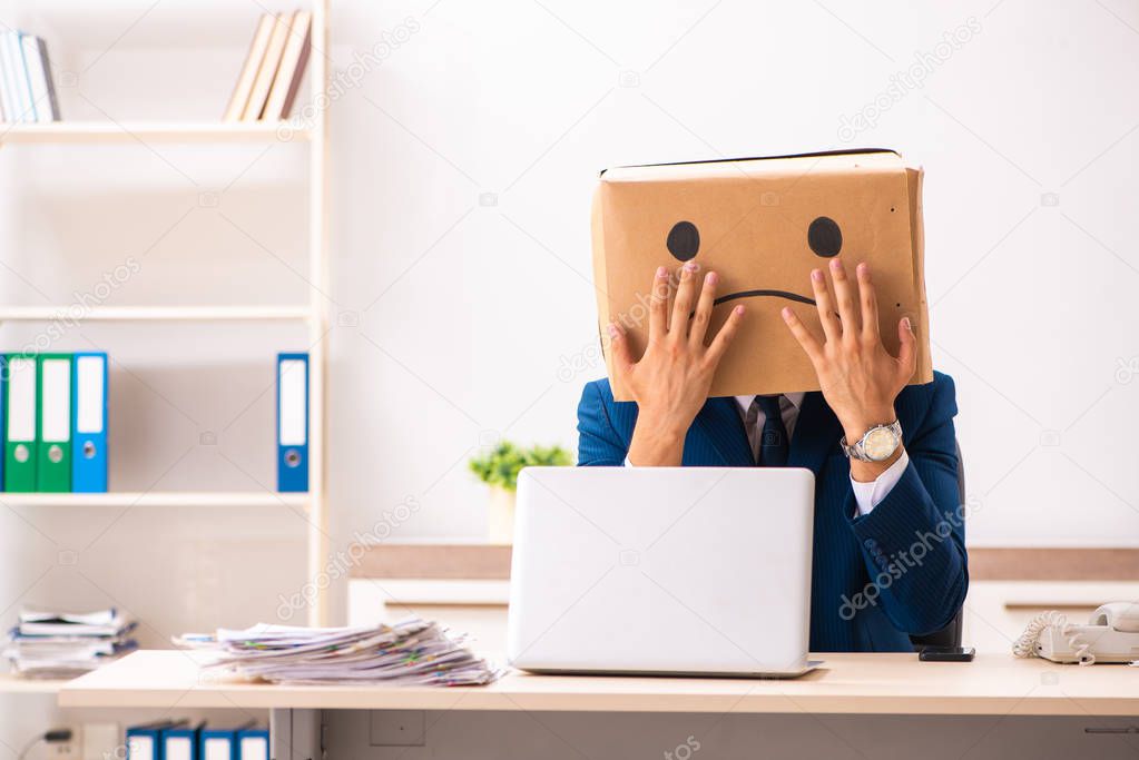 Unhappy man employee with box instead of his head 