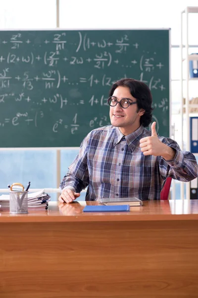 Jovem professor de matemática engraçado na frente do quadro — Fotografia de Stock