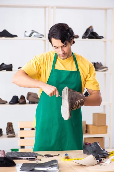 Joven reparando zapatos en taller — Foto de Stock