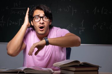 Genç erkek öğrenci sınıfta oturuyor