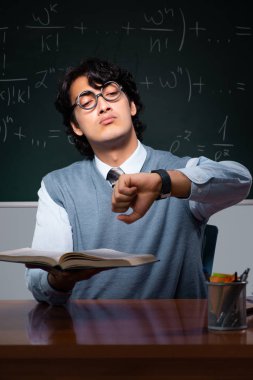 Kara tahta önünde genç matematik öğretmeni