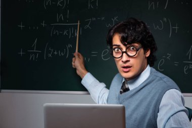 Kara tahta önünde genç matematik öğretmeni