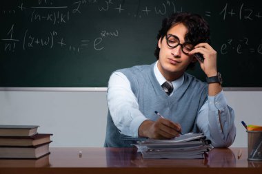 Kara tahta önünde genç matematik öğretmeni