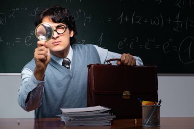 Kara tahta önünde genç matematik öğretmeni