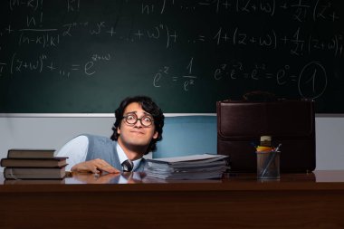 Kara tahta önünde genç matematik öğretmeni