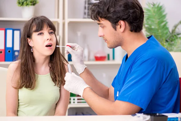 Médico recibiendo muestra de la prueba de saliva en el hospital clínico —  Fotos de Stock