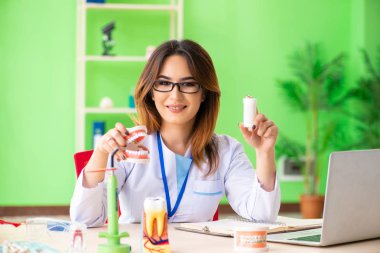 Diş implantı üzerinde çalışan kadın dişçi.