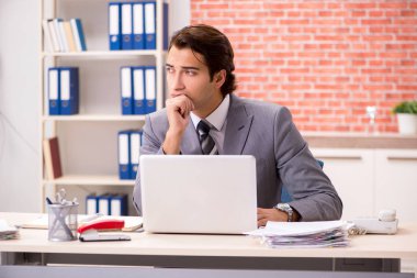 Ofiste çalışan genç bir işadamı.