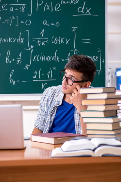 Jonge mannelijke student studeert wiskunde op school — Stockfoto