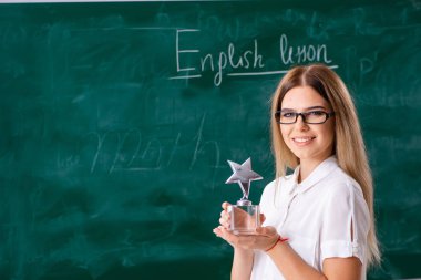 B önünde duran genç kadın İngilizce öğretmeni