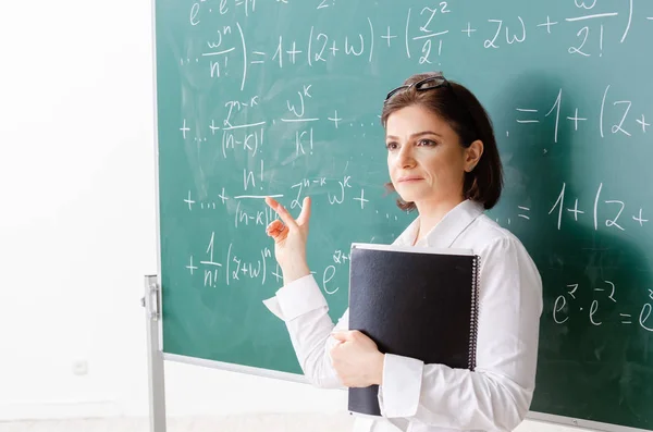 Nauczyciel matematyki kobiet przed chalkboard — Zdjęcie stockowe
