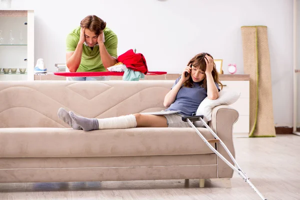 Чоловік допомагає травмованій нозі дружині в домашніх умовах — стокове фото