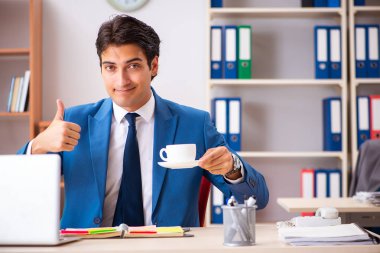 Genç yakışıklı işadamı ofiste çalışıyor. 