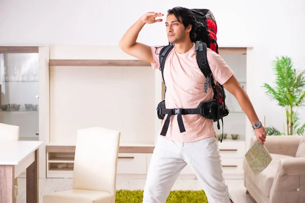 Joven turista masculino preparándose para el viaje en casa — Foto de Stock