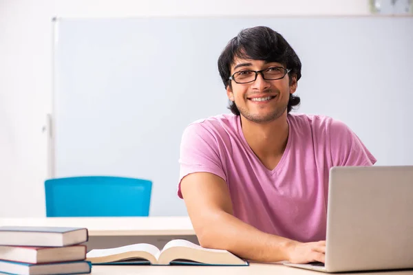 Jovem estudante do sexo masculino sentado na classe — Fotografia de Stock