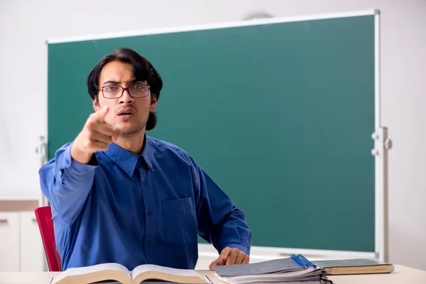 Jonge mannelijke leraar voor schoolbord — Stockfoto