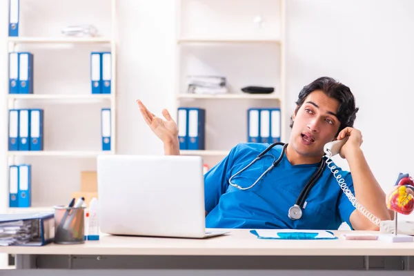 Mladý pohledný doktor pracuje na klinice — Stock fotografie