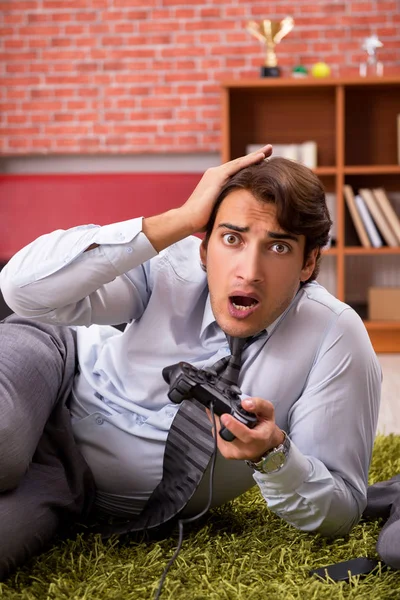 Jovem funcionário jogando joystick jogos durante sua pausa — Fotografia de Stock