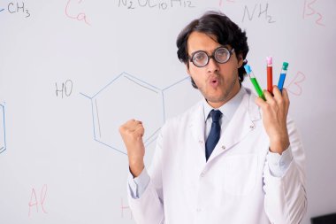 Beyaz tahta önünde genç komik kimyager 